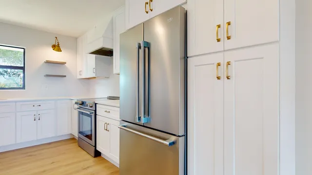 a kitchen with a stove and white cabinets