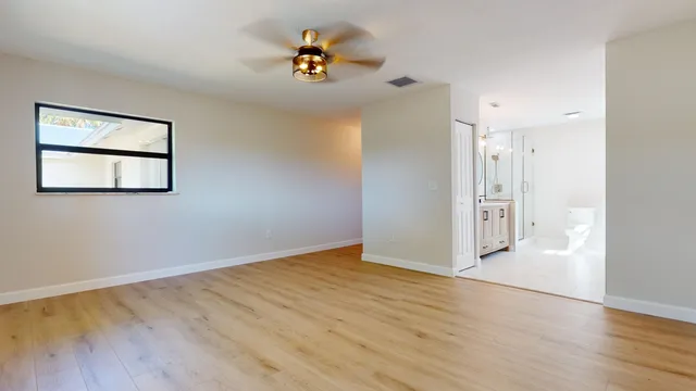 a view of a big room with wooden floor and windows
