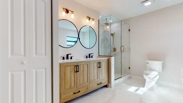 a utility room with a sink a toilet and a mirror