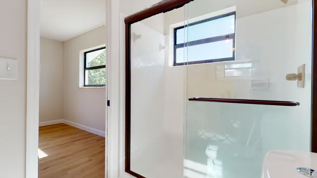 an empty room with wooden floor and a backyard
