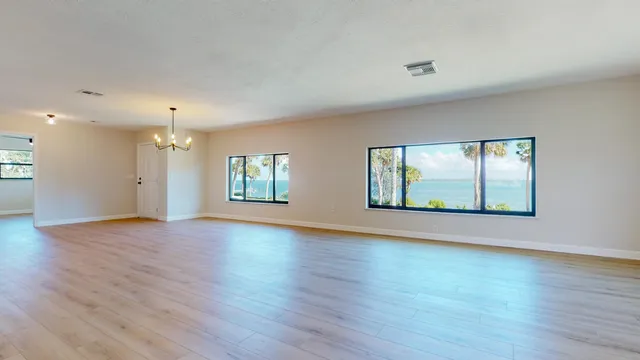 a view of a room with wooden floor and kitchen view