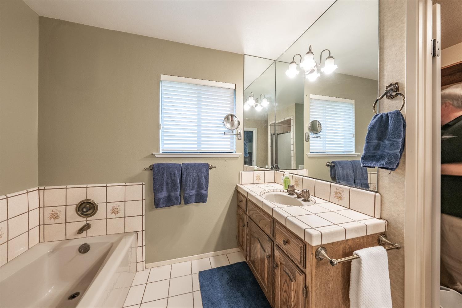 28 Seasons Court Madera, CA 93637 - Photo 21 of 47 a bathroom with a tub sink and mirror