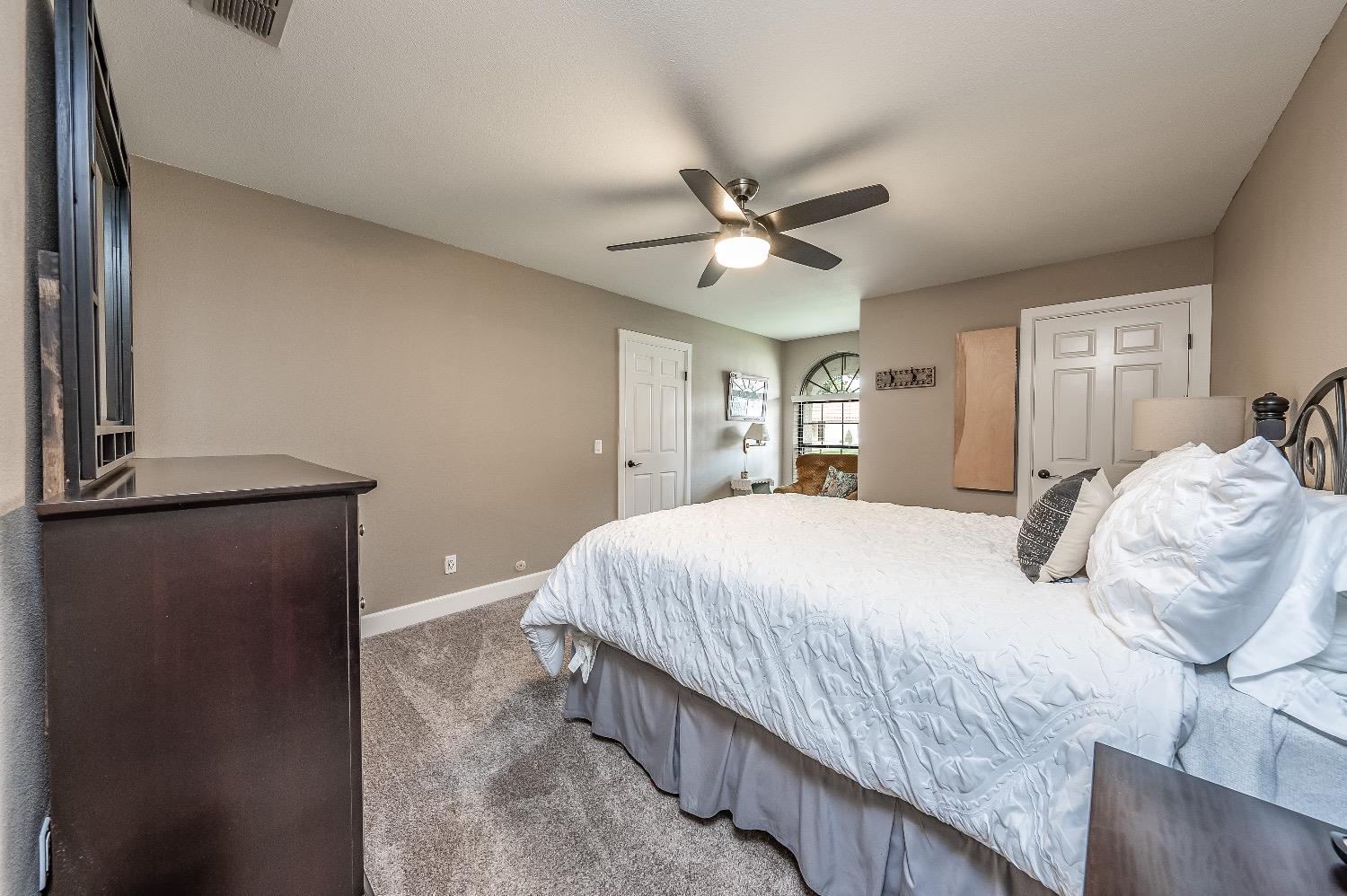 28 Seasons Court Madera, CA 93637 - Photo 25 of 47 a bedroom with a bed and a chandelier