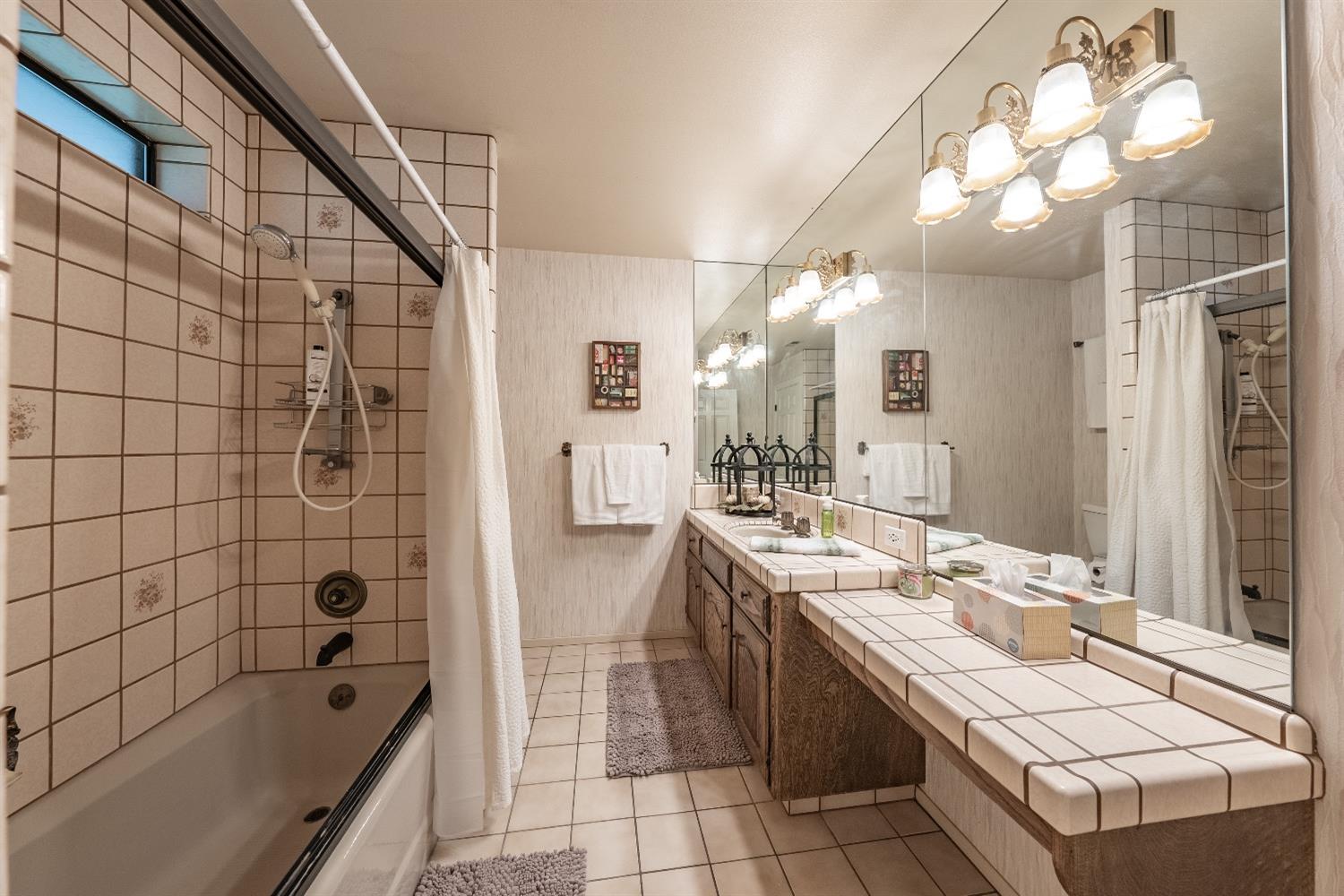 28 Seasons Court Madera, CA 93637 - Photo 26 of 47 a bathroom with a granite countertop sink a toilet a mirror and shower