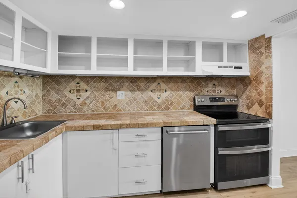 a kitchen with granite countertop a sink and a stove
