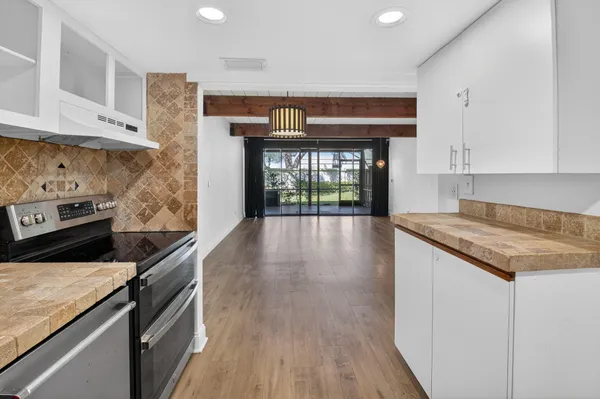 a kitchen with granite countertop a stove and cabinets