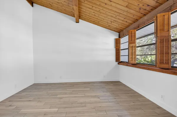 a view of empty room with wooden floor