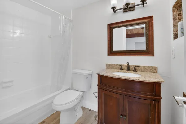 a bathroom with a granite countertop toilet sink and shower