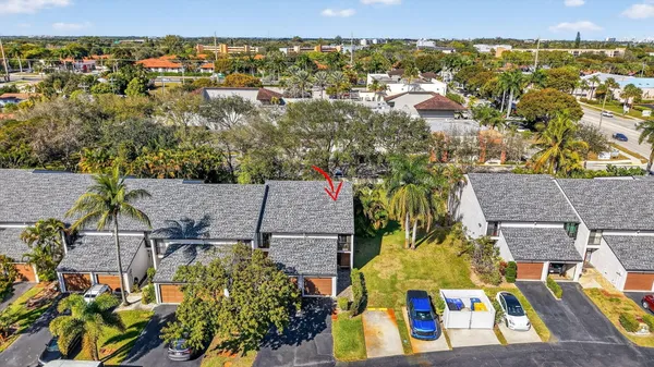 an aerial view of a house with swimming pool and large trees