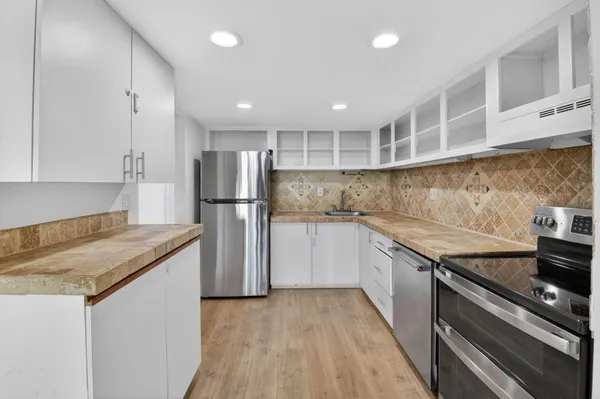 a kitchen with granite countertop stainless steel appliances and wooden cabinets