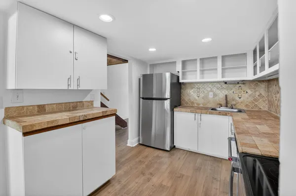 a kitchen with a refrigerator and a sink