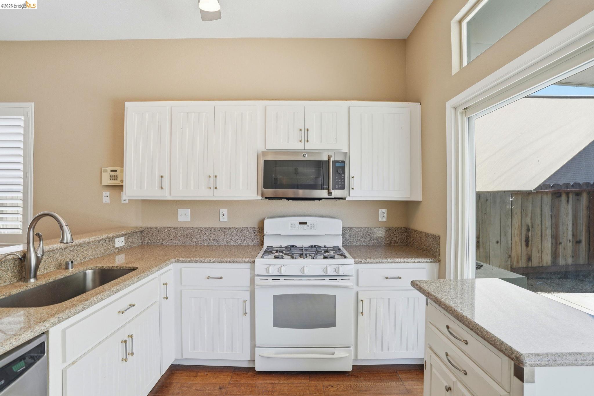4465 Fall Lane Oakley, CA 94561 - Photo 17 of 26 a kitchen with granite countertop a stove sink and cabinets
