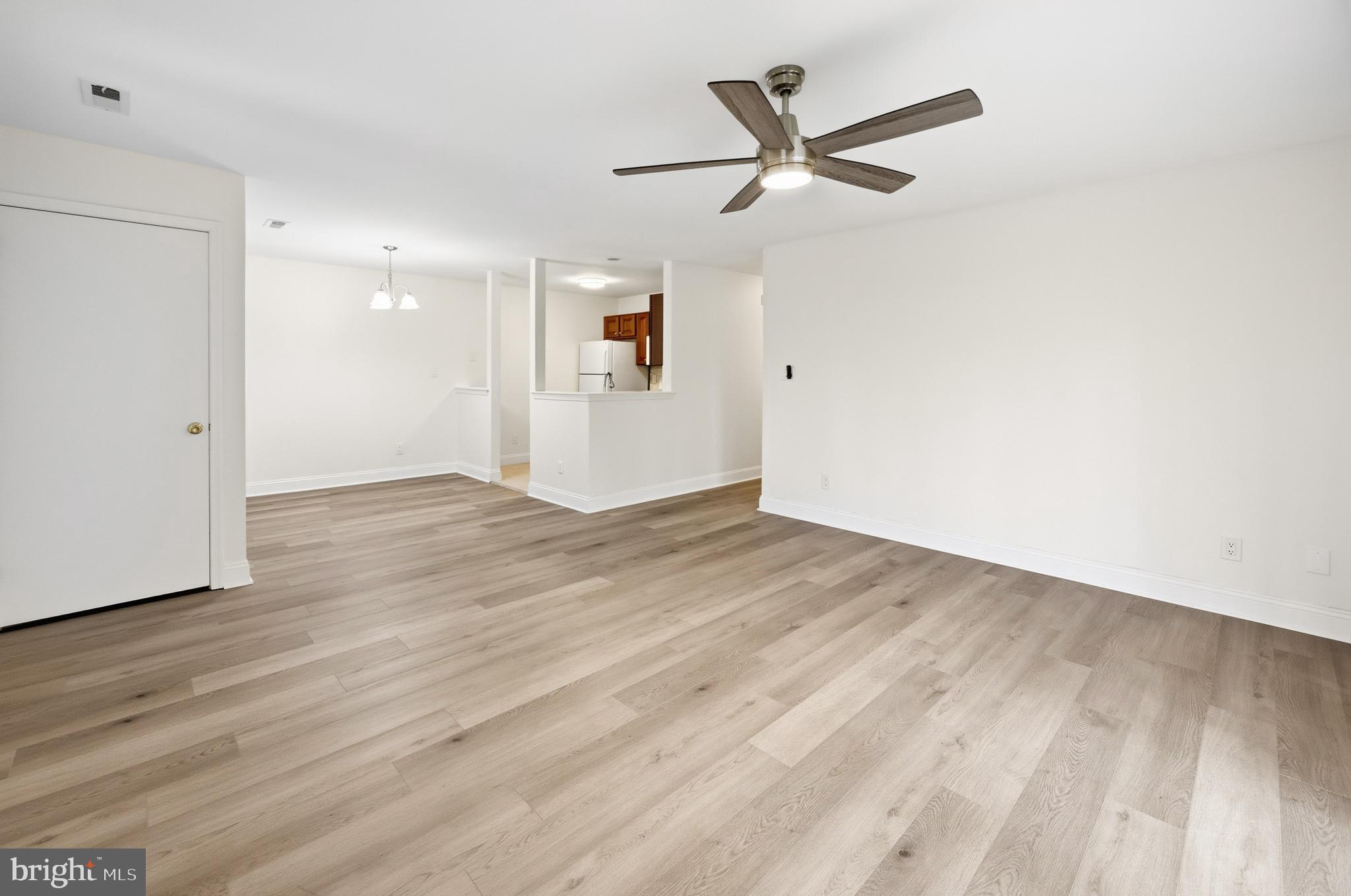 705 Quail Road Marlton, NJ 08053 - Photo 2 of 28 an empty room with wooden floor a ceiling fan and a window