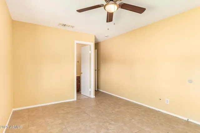 an empty room with a ceiling fan and a window