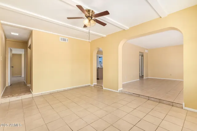 a view of a big room with wooden floor and chandelier fan