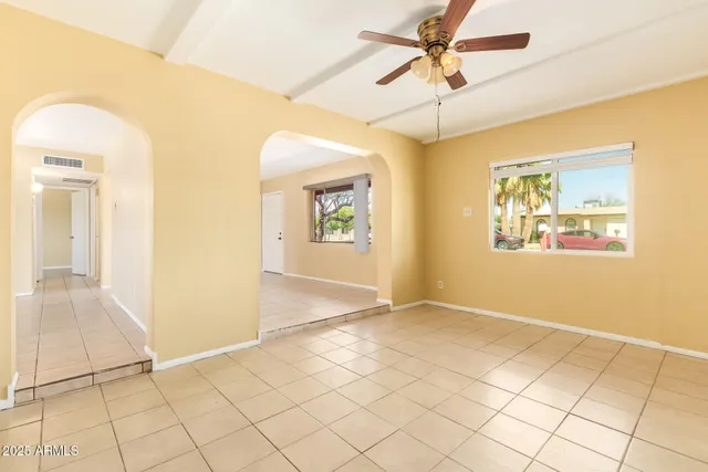 an empty room with windows and fan