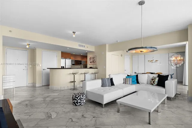 a living room with furniture and a dining table with kitchen view