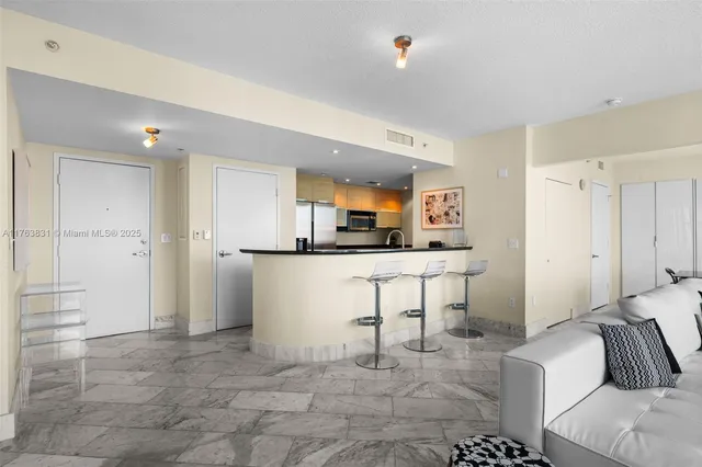 a kitchen with stainless steel appliances kitchen island granite countertop a refrigerator and a sink