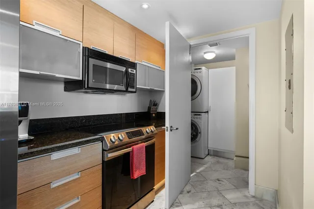 a kitchen with stainless steel appliances a sink a stove a refrigerator cabinets and a dining table