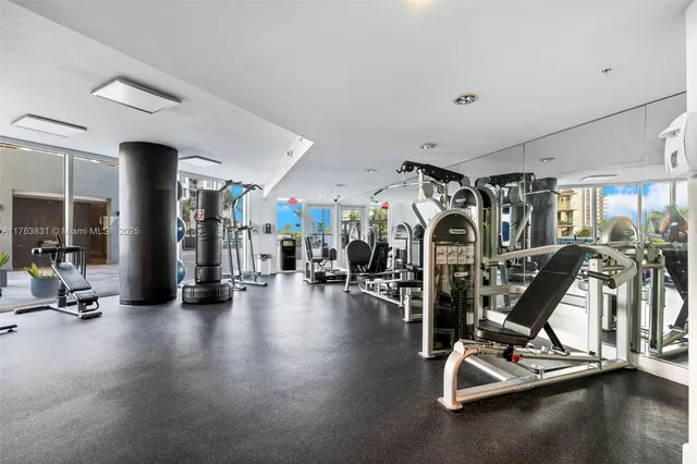 a living room with furniture gym equipment and a large window