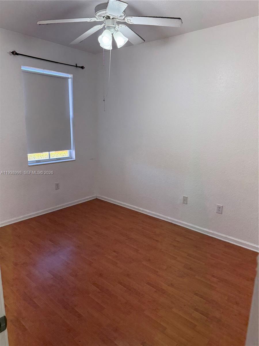 12260 Southwest 27th Street, Unit 1303 Miramar, FL 33025 - Photo 31 of 58 an empty room with a chandelier fan and wooden floor