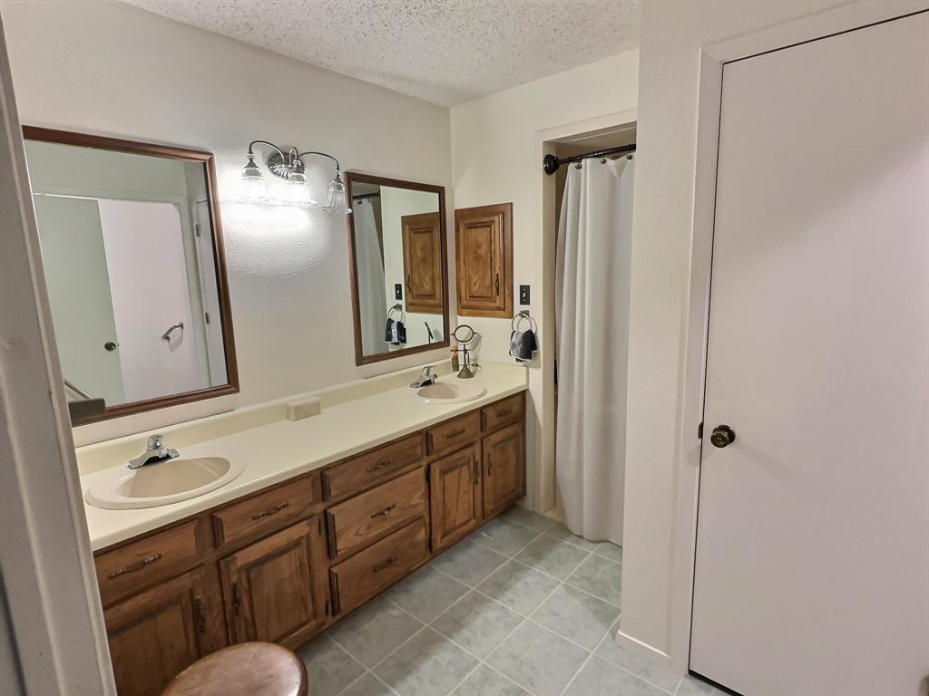 3718 Highway 36 Rising Star, TX 76471 - Photo 21 of 40 a spacious bathroom with a double vanity sink a large mirror and shower