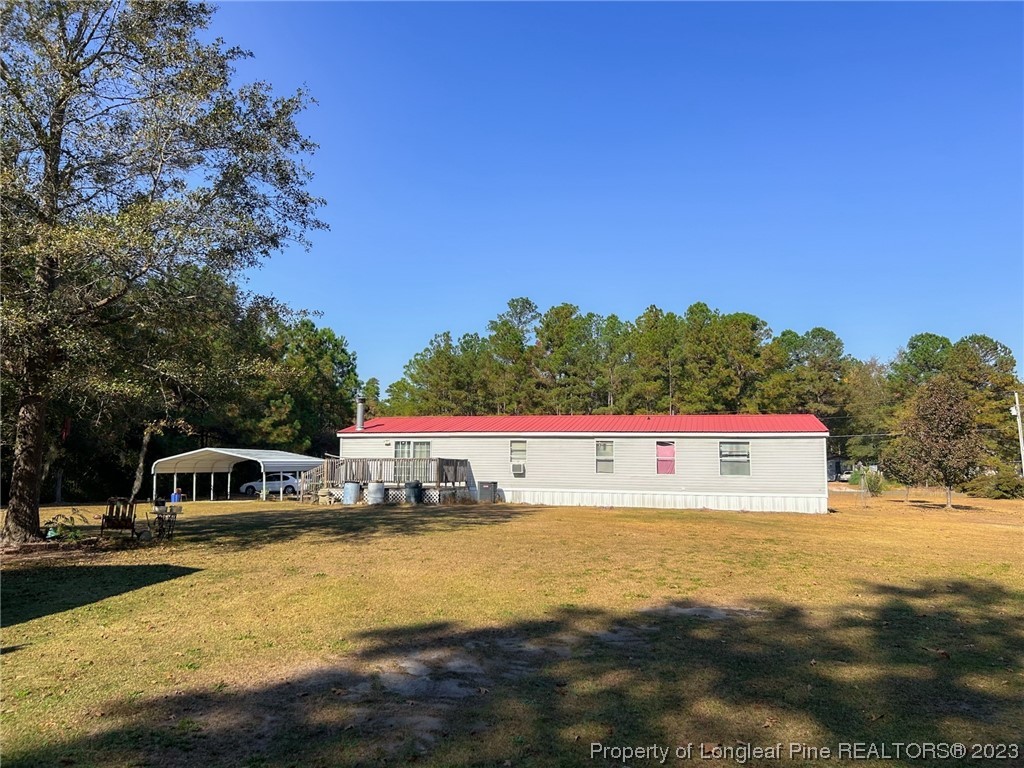 259 Burch Road Lumberton, NC 28360 - Photo 5 of 13 a view of a swimming pool with lawn chairs and a big yard