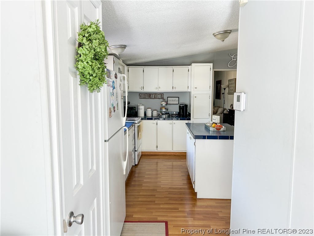 259 Burch Road Lumberton, NC 28360 - Photo 6 of 13 a kitchen with a refrigerator a stove top oven and white cabinets