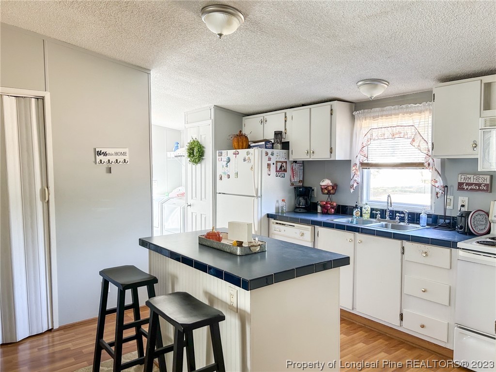 259 Burch Road Lumberton, NC 28360 - Photo 9 of 13 a kitchen with stainless steel appliances granite countertop a stove a refrigerator a sink and white cabinets with wooden floor