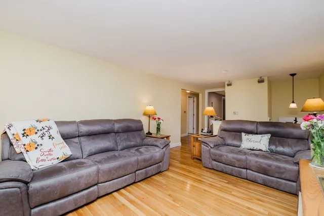 a dining room with furniture a chandelier and wooden floor