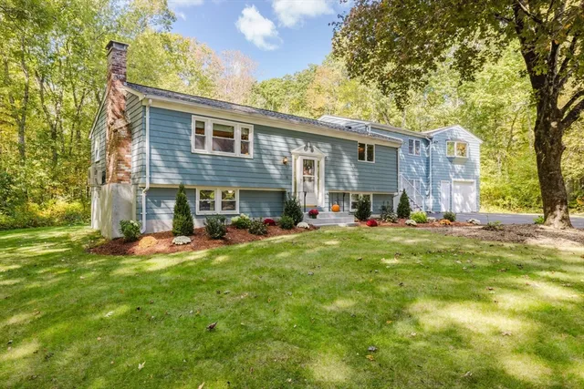 a view of a house with a yard and sitting area