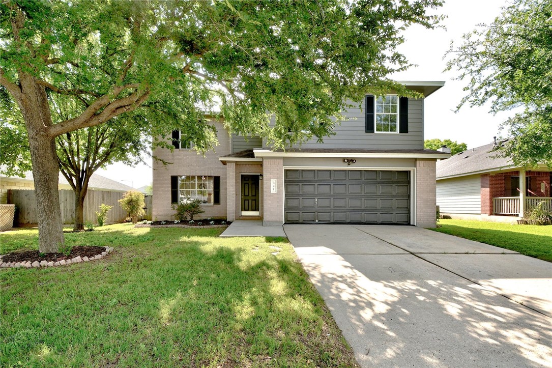 321 Nicole Way Bastrop, TX 78602 - Photo 1 of 1 a front view of a house with a garden and trees