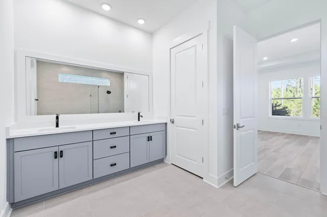 a spacious bathroom with a double vanity sink and a mirror
