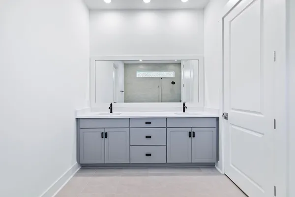 a spacious bathroom with a double vanity sink and a mirror