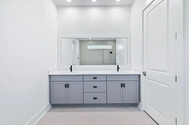 a spacious bathroom with a double vanity sink and a mirror