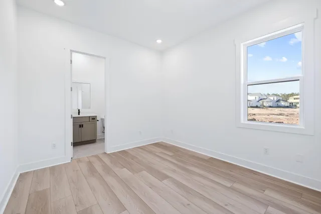 an empty room with a window and wooden floor