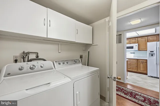 a view of washer and dryer with kitchen in the background