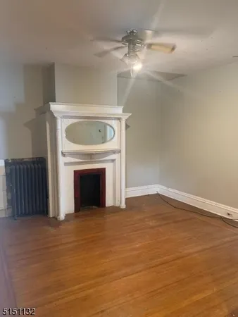 a view of empty room with wooden floor and fireplace