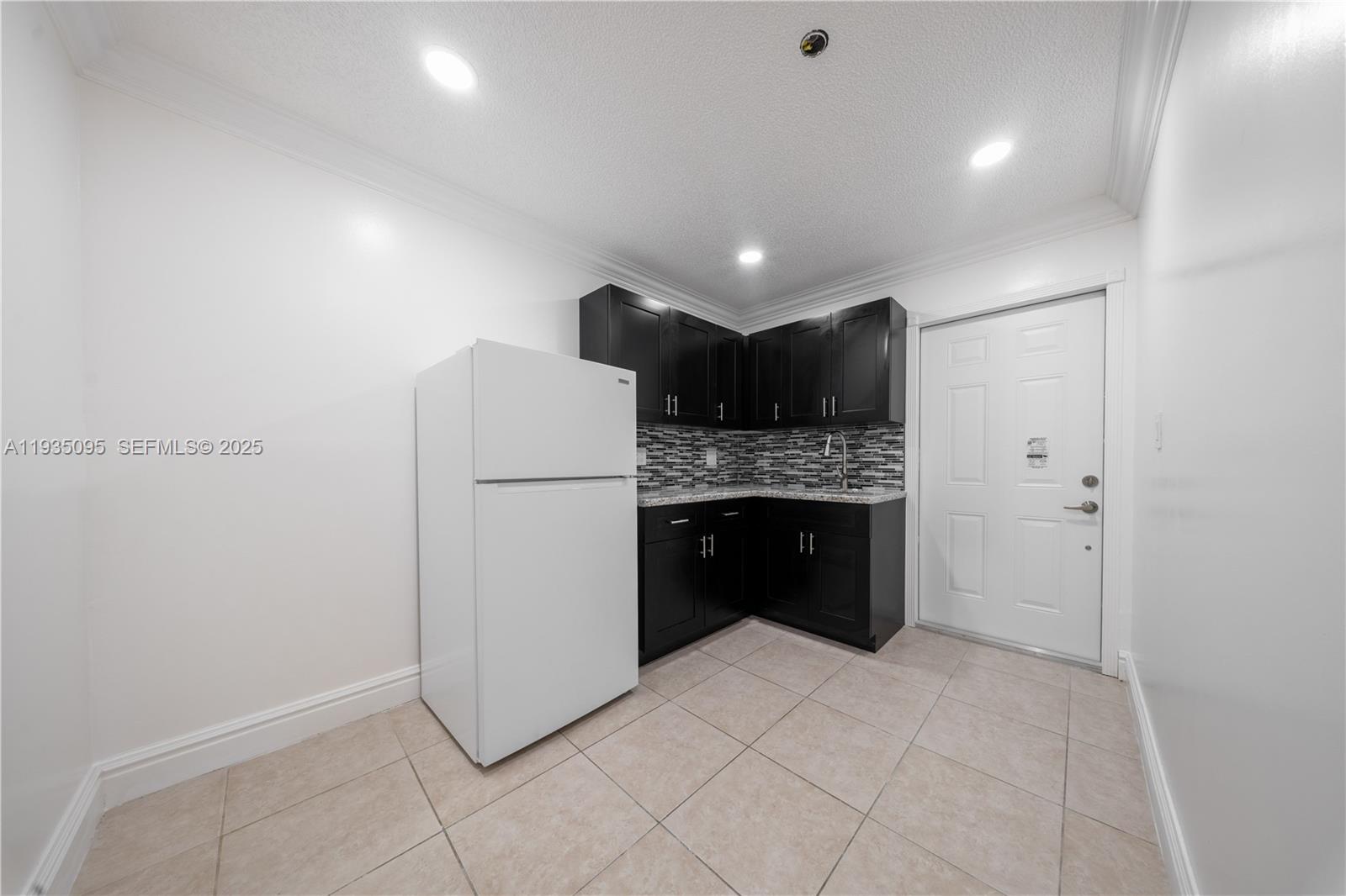 3219 Southwest 141st Avenue, Unit 1 Miami, FL 33175 - Photo 5 of 17 a kitchen with a refrigerator and a sink