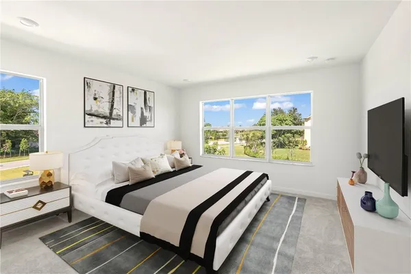 a bedroom with a bed and a flat tv screen on dresser
