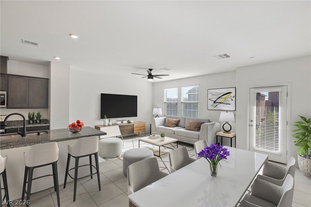 6227 Runestone Street Las Vegas, NV 89113 - Photo 11 of 33 This open concept living space features a kitchen island, seamlessly connecting to the dining and living areas.