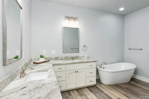 a spacious bathroom with a granite countertop toilet a sink and a mirror