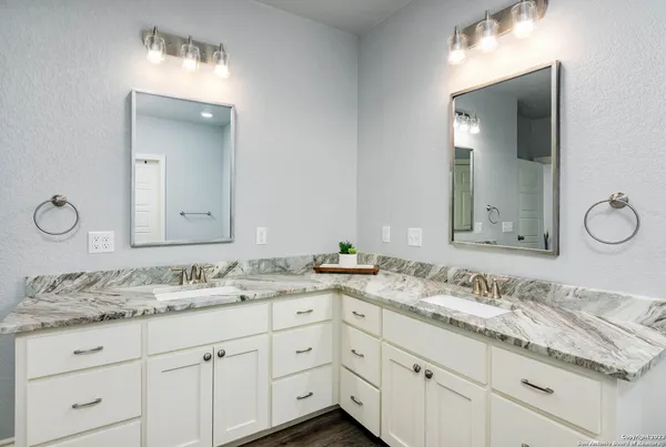 a bathroom with a granite countertop sink double and mirror