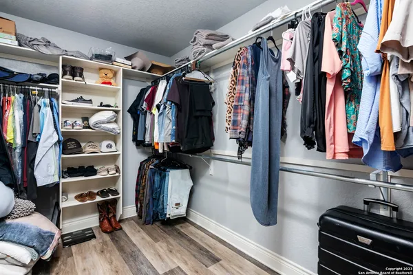 a view of walk in closet with clothes and shoes