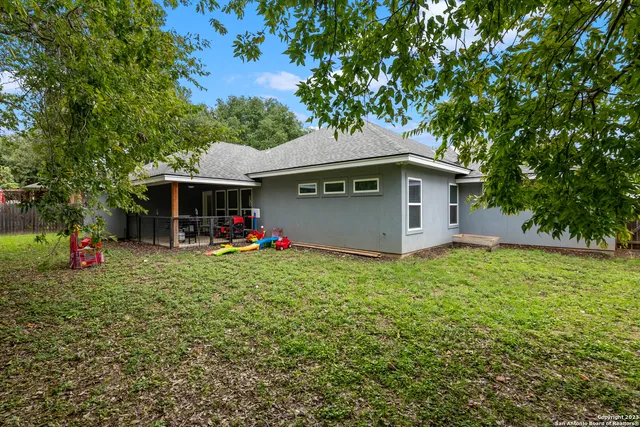 a backyard of a house with table and chairs