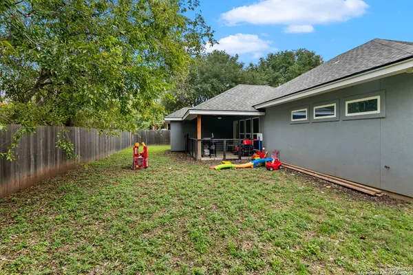 a view of a house with backyard and furniture