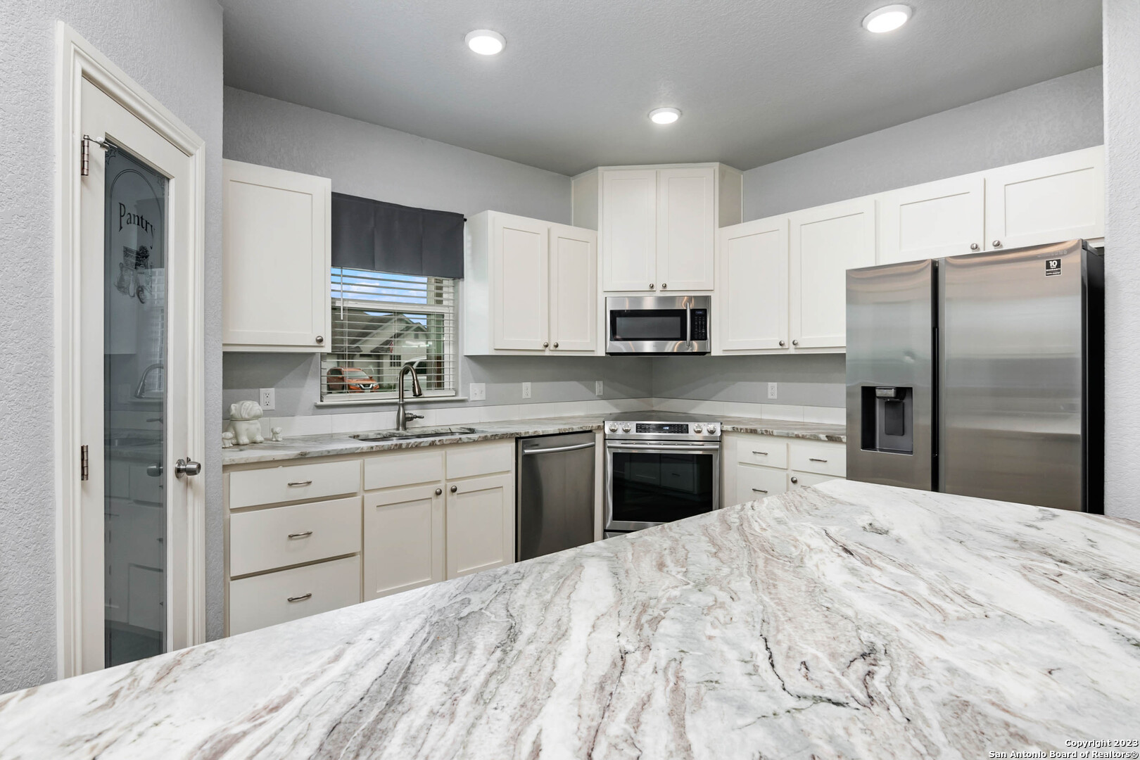 230 Club View West Seguin, TX 78155 - Photo 9 of 24 a kitchen with stainless steel appliances kitchen island granite countertop a refrigerator sink and white cabinets