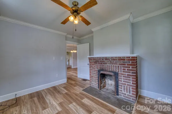 an empty room with a fireplace and fan