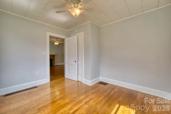 an empty room with wooden floor and closet