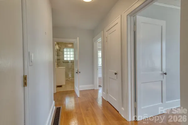 a view of a hallway with wooden floor and closet